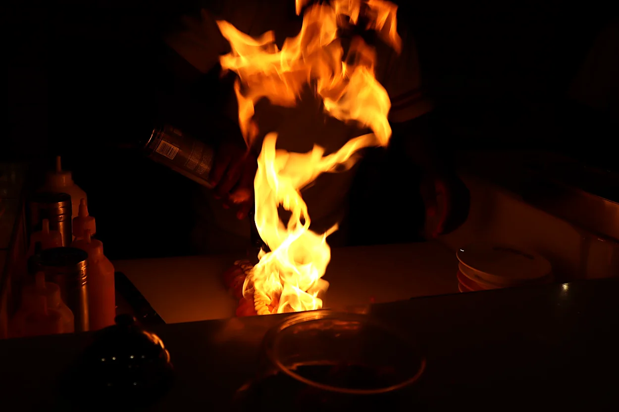 Flames rise during cooking in the Big Bowls kitchen